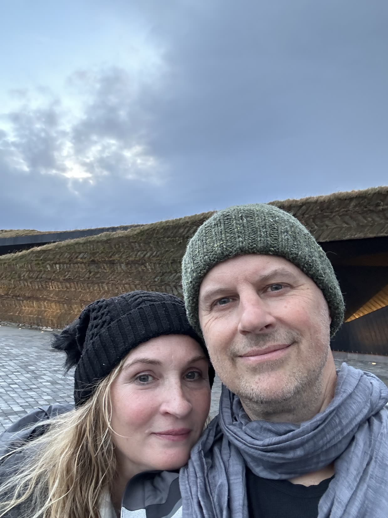 Lisa Hirst and David Carnes outside in winter beanies under a moody sky